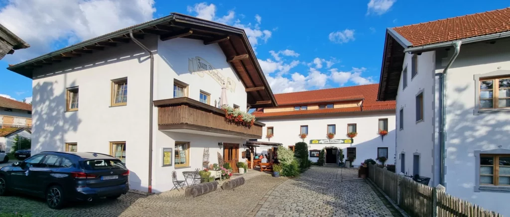 Gasthof mit Biergarten vom Dorfplatz Arnbruck aus gesehen Gasthof mit Biergarten und Gästehaus Ausflugslokal Bayerischer Wald